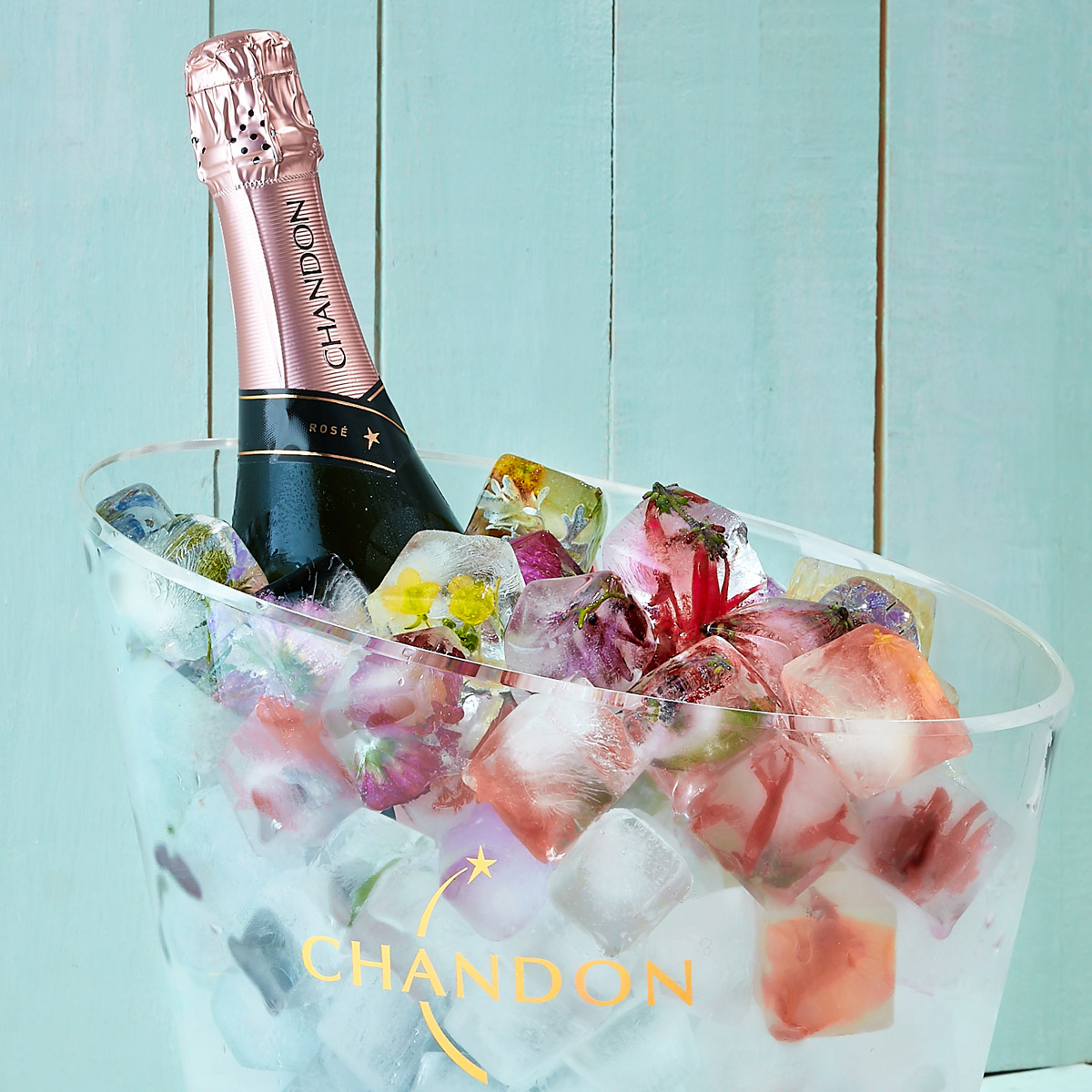 bouteille de pétillant rosé dans un seau à glace transparent et galçons aux fleurs