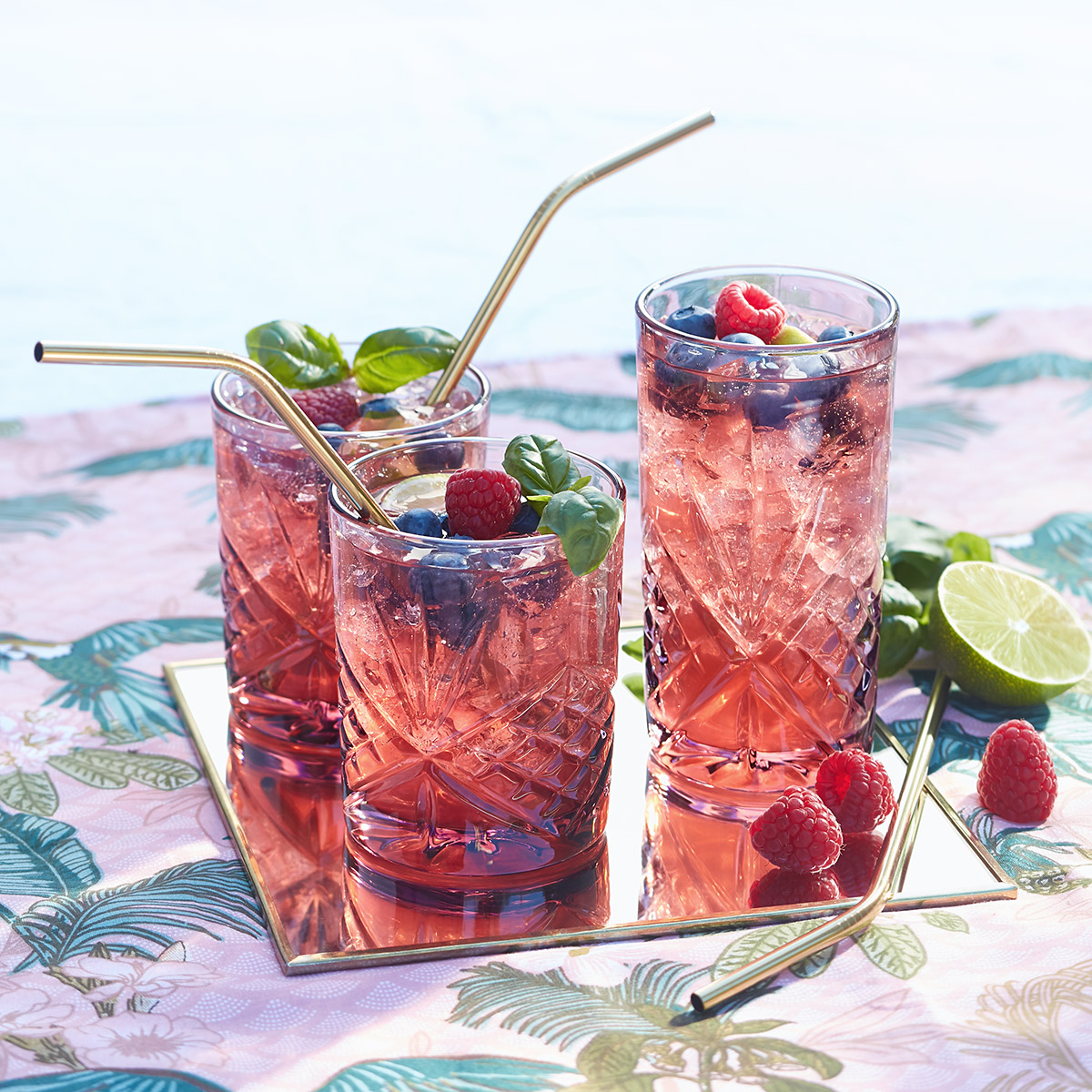 Cocktail fruité : vin pétillant, framboises, myrtilles, citron vert et basilic