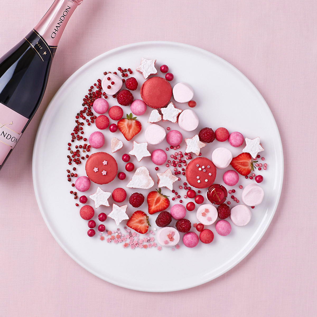flatlay composition en forme de cœur en sucreries roses, macarons, guimauves, bonbons
