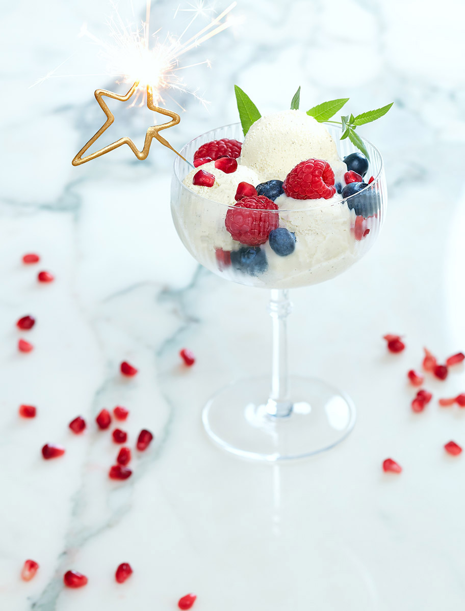 Coupe de glace à la vanille, framboise, myrtilles et grenade et feu de bengale